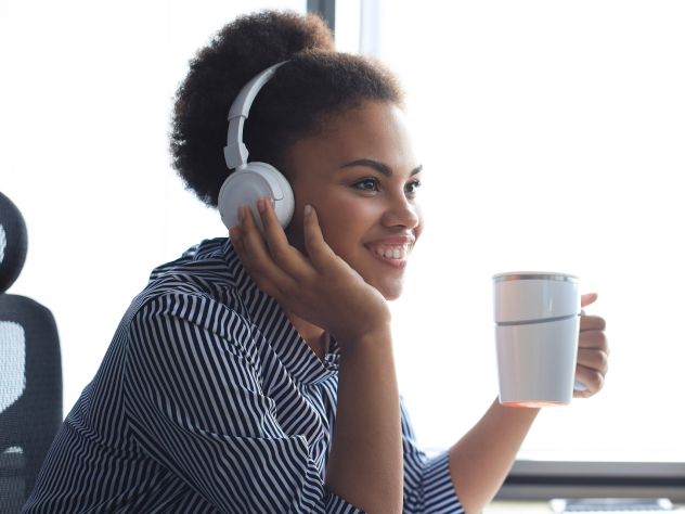 A young woman listens to a podcast